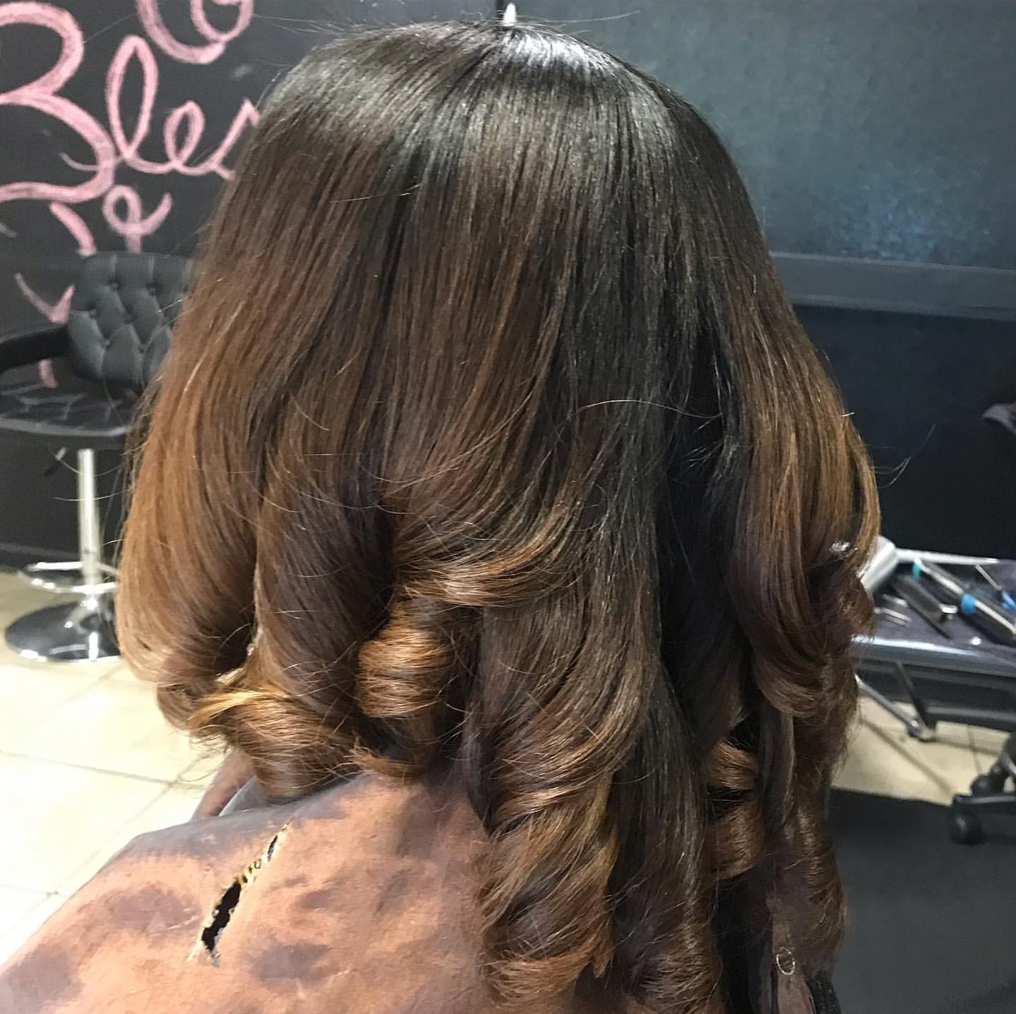 Caramel-toned curl styling finished with bounce and body